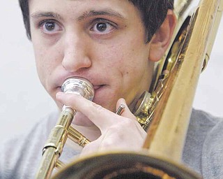 Boardman High School 12th grade band member Tony Colella plays trombone during practice. Celella is one of 275 musicians in the Marching Band who have split up into other bands and ensembles for the winter season.