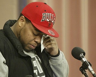William D. Lewis the vindicator YSU student Adrian Watson wipes away atear before reading a poem during a prayer service on YSU campus Monday. Watson knew shooting victim Jamil Johnson and wrote poem about him.