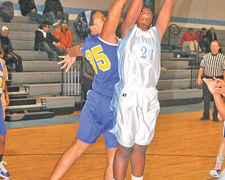 (21) Ashlyn Baker of East is fouled by (35) Monet Saunders during thier game Monday night in Youngstown.