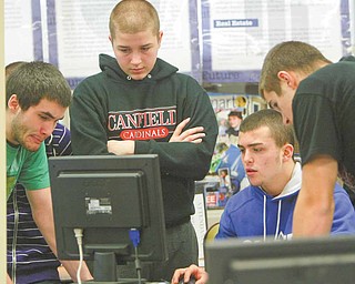 Canfield High School students work to edit a commercial they made, advertising the clothing they will sell through their Intro to Business class. Seniors Brad Kelly, left, Ryan Camardo and Ryan O’Hara and freshman Alex Heldrerk shot the video in class last week.