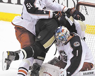 Pittsburgh Penguins' Jordan Staal, center, is shoved into Columbus Blue Jackets goalie Steve Mason (1) by defenseman Fedor Tyutin (51) during the first period of an NHL hockey game in Pittsburgh, Tuesday, Feb. 8, 2011.
