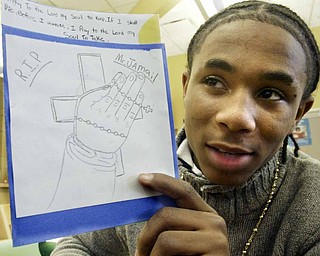 Wilson Middle School eighth grader Lynell Lockhart holds a card he made in memory of the late Jamail Johnson who was a math tutor at Wilson.