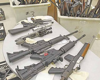 The 232 weapons in three large rolling bins and four milk crates were on display at the Cleveland Police headquarters confiscated from Abbot John Henry of St. Herman's House of Hospitality in Cleveland February 8, 2011. Investigators with Henry's consent rounded up 80 guns with ammunition from a home near St. Herman's. On Friday, another 150 guns and ammunition were recovered from a Trumbull County farm the shelter owns.