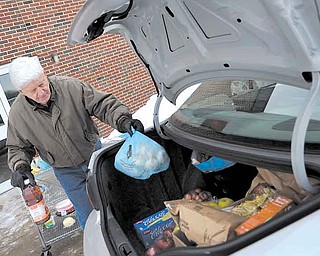 Volunteer Mel Petefish of Liberty, loads a car full of donated food from Share Outreach program Wednesday afternoon. The program runs out of the Pleasant Valley Church in Niles once a week and provides food and clothing to those in need.