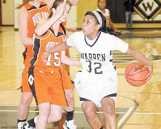 Warren Harding’s Kourtney Williams (32) drives to the hoop as (15) Paige Loychik (15) and Taylor Williams defend during their basketball game Thursday in Warren. The Tigers (17-1) took the lead midwaythrough the first period and never trailed on the way to a 45-44 victory.