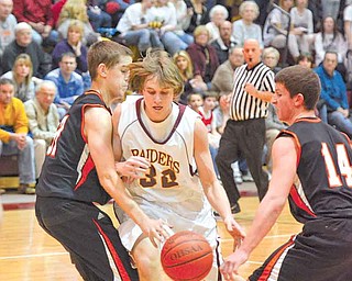 South Range junior Jordan Baker tries to maintain possession of the ball while his guarded by (14) Brad Ferraro and (31) Ron Rogers.