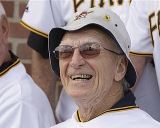 FILE - In this June 30, 2009, file photo, former Pittsburgh Pirates manager Chuck Tanner smiles during a photo next to a replica of the outfield wall at Forbes Field on display at PNC Park in Pittsburgh. Tanner, who managed the Pirates to one of the greatest comebacks in World Series history, died Friday, Feb. 11, 2011, at his home in New Castle, Pa., after a long illness, the team Pirates said. He was 81. (AP Photo/Gene J. Puskar, File)