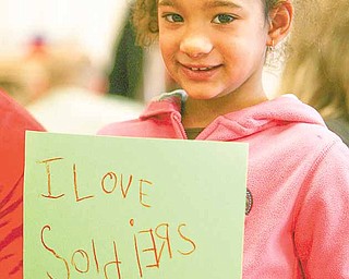 Alaina Moody proudly shows off the Valentine’s Day card that she and her military partner made for troops in Afghanistan.