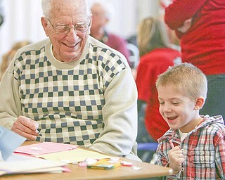 Aidan Hankey, right, and William Ronci from Shepherd of The Valley-Poland and a World War II Army veteran, share a laugh while making Valentine’s Day cards to be sent to military personnel in Afghanistan. Aidan is a kindergarten student at Zion Christian School at Zion Lutheran Church in Youngstown. Ronci fought in several battles with the 3rd and 7th Armies in their drive across Europe toward Germany. A group of young veterans, members of the Armed Forces Student Association at Youngstown State University, also participated in the event sponsored by Shepherd of the Valley Home Health.