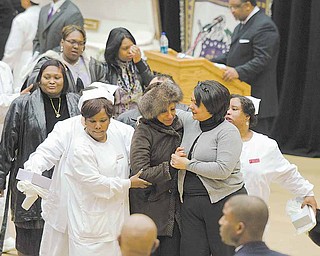 A mourner is escorted away from the casket of shooting victim Jamail Johnson during Saturdays calling hours at YSU's Beeghly Center.