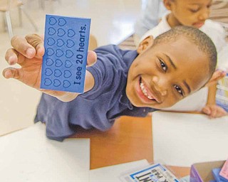 Darnell Jones, 6, a kindergarten student at Taft Elementary School on Youngstown’s South Side, shows off a stamp he uses to learn counting and reading. Through DonorsChoose.org, teachers at the school have received educational resources and teaching aids through donations — sometimes from complete strangers.