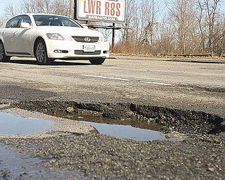 Potholes such as this one in the 1400 block of South Avenue are easy to spot during the day but can be masked in puddles and during night travel. They can cause damage a vehicle’s tires, alignment and suspension.