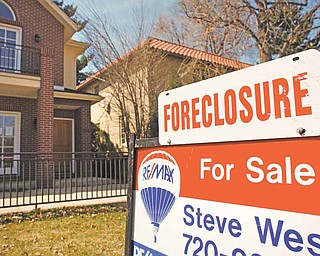 In this April 4, 2010 file photo, a forclosure sign tops the for sale sign outside a home in Denver. Foreclosure activity jumped in 149 of the 206 largest metropolitan areas in the U.S. last year, foreclosure listing firm RealtyTrac Inc. said Thursday Jan. 27, 2011.