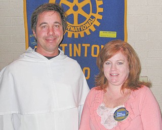 Doing right against blight: The Rev. Greg Maturi, from St. Dominic Church, informed members of the Rotary Club of Austintown about Operation Redemption on the South Side. The area around the church has seen 20 vacant homes demolished, and the 45 that remain are targeted for rehabilitation. Rotary President Susan Leetch, above, right, presented Father Maturi with a certificate of appreciation and showed a book to be donated to Woodside School Library in Austintown, as is done each week in honor of the speaker. At the same meeting, Jennifer Connolly was inducted into the Rotary Club. She is the administrator of Briarfield Assisted Living in Austintown.