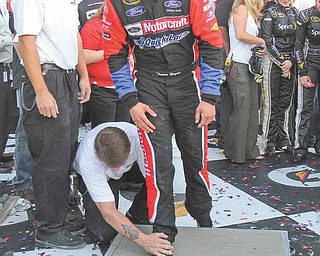 Trevor Bayne leaves his foot imprints in cement in Victory Lane after winning the Daytona 500 at Daytona International Speedway in Daytona Beach, Florida, Sunday, February 20, 2011. (Gary W. Green/Orlando Sentinel/MCT)