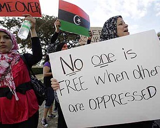 Libyan-American citizen Jamila Rashed, right, of Denton, Texas, holds a sign as she joins nearly 200 others during a rally at Dealey Plaza, Sunday, Feb. 20, 2011, in Dallas. Rashed said that she responded to a message on a social network site that called for the rally at the downtown Dallas plaza in support of a freedom in the country of Libya.