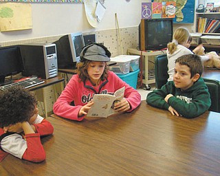 Sharing their talents: Seventh-graders from the honors literature class recently shared their storytelling talents with first- and third-graders at St. Patrick School in Hubbard. The readers enhanced their stories with hats and props. Gina Madeline reads from “The Great Mouse Detective.”