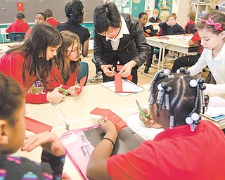 Visiting Chinese educator Nancy Zhang demonstrates the traditional art of Chinese paper-cutting in a fourth-grade classroom Tuesday morning at Campbell Elementary School. Zhang and fellow educator Judy Teng arrived here Feb. 4 and will go back to China Friday.