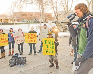 Robert Heltzel of Niles, right, leads a group of anti-war protesters who yelled at and heckled those attending the Republican dinner with Rove. Some of the protesters opened the main door to the event and tried to get inside. They were stopped by Niles police.