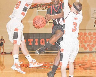 Campbell's Ty Underwood drives to the rim as Cody Dillon (10) and Matt Brazin play defense during their game Tuesday night in Newton Falls.