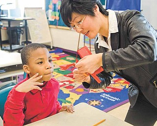 Jordan Weatherly, 9, gets personal instruction from Nancy Zhang during the Chinese paper-cutting lesson.