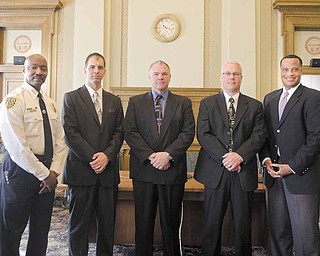 Youngstown Police Chief Jimmy F. Hughes, from left, newly-promoted city police officers Lt. Jason Simon, Lt. William Ross and Capt. Mark Milstead, and Mayor Jay Williams stand together in city council chambers. The three were sworn in to their new positions during a ceremony Tuesday.