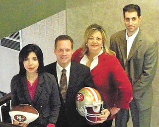 Above, displaying a San Francisco 49ers football and helmet that will be among the auction items at the Mardi Gras are, from left, Denise DeBartolo York, owner of the 49ers; Ted Schmidt, PNC regional president; Liz McGarry, Hospice director of development; and Ryan Pastore, PNC director of client and community relations. Below, culinary art students at Choffin Career and Technical Center were asked to make King Cakes for the party. Cakes, made from two different recipes, were sampled and voted on by McGarry and Terrance Escarco of Hospice and the students. Standing behind Dasia’n Square, who is holding a cake baked from the winning recipe, are, from left, Charles Crosby, Myeila Carter, Tre Little, James Donaldson and Darryl Kempson.