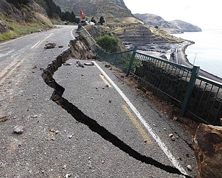 Part of a road between Lyttelton and Sumner is damaged by Tuesday's earthquake on the outskirts of Christchurch, New Zealand, Thursday, Feb. 24, 2011. The magnitude-6.3 temblor collapsed buildings, caused extensive other damage and killed dozens of people in the city.