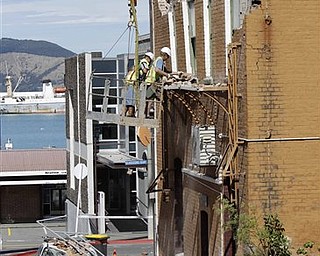 Workers clear debris of a building damaged by an earthquake in Lyttelton on the outskirts of Christchurch, New Zealand, Thursday, Feb. 24, 2011. Tuesday's magnitude-6.3 temblor collapsed buildings, caused extensive other damage and killed dozens of people in the city.