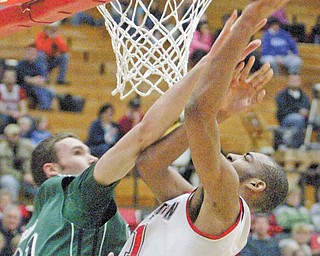 Youngstown State’s Damian Eargle (21) shoots over Alec Brown of Green Bay in fi rst-half action of Thursday’s Horizon League contest at YSU’s Beeghly Center. Eagle posted 19 points and seven rebounds for the Penguins, who came up short against the Phoenix, 71-60.