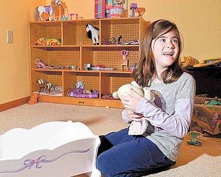 Nicole Barber, a third-grader at Springfield Local Elementary School, plays with one of her favorite toys in her room at her New Middletown home. Nicole, born with spina bifida, was saved from symptoms of severe spina bifida by fetal surgery she and her mother, Lorie, underwent nine years ago.
