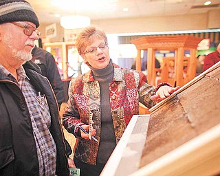 Debbie Martin of Leroy Township explains the Leaf Filter gutter protection system to Dennis Keith of Youngstown at the 60th annual HBA Home and Garden Show at Mr. Anthony's in Boardman Saturday.