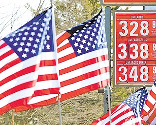 American flags blow in the wind outside a Gibbs gas station where a sign shows the new price of gasoline, Thursday, Feb. 24, 2011, in Topsham, Maine. Gasoline for U.S. motorists already costs more than at any point since 2008, despite ample supplies.