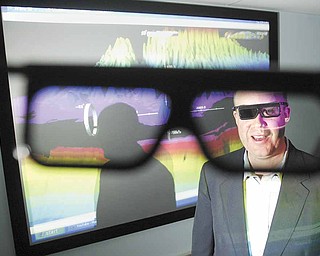 Brad Shellito, geography professor at Youngstown State University, dons 3-D glasss while demonstrating the geography department’s new GeoWall 3D projection system inside the Phelps building on campus.