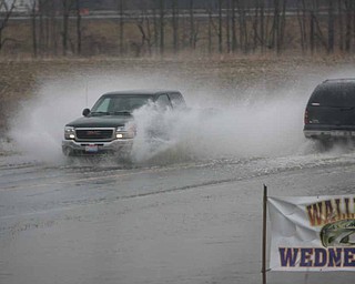 SURFS UP and Walleye Wednesday can't be far behind as a motorist blows through the water covering the road by Drakes Landing on Western Reserve Road.