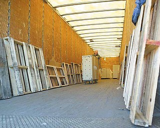 A worker from Carney-McNicholas Inc., a moving company in Austintown, unloads a fi ling cabinet from one of many semi trucks used to deliver the former Delphi Corp. furniture. It will take more than 40 truckloads to deliver all 4,500 pieces of furniture to Austintown.