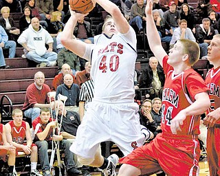 Salem’s Anthony Shivers (44) tries to keep Struthers’ Adam Ryczaj (40) from scoring during their Division II tournament basketball game Wednesday at Boardman. The Wildcats defeated the Quakers, 65-46.