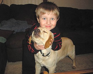 Justin Bish, 3 1/2 years old, is trying to get his new puppy, Sparky, to face the camera so his grandma, Pam Filo of Hubbard, can snap the picture.