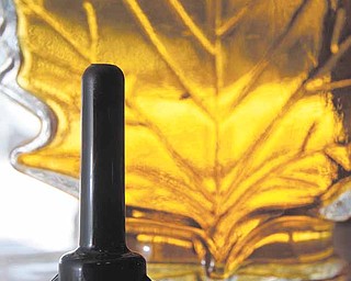 In this March 4, 2011 photo, a Check Valve Adapter is seen with a bottle of maple syrup in East Montpelier, Vt. The device was developed by maple researchers at the University of Vermont as a means of extending the six-week sugaring season. (AP Photo/Toby Talbot)