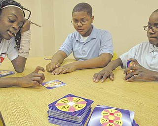 From left, Rayen Early College math students, Jah-Nice Berry and Jordan Rawl, both seventh-graders, and Carlos Hall, a sixth-grader, play a math game called Challenge 24.