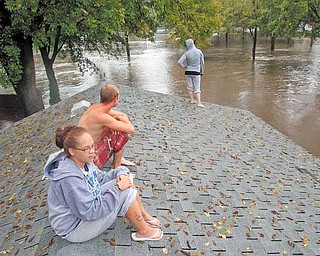 FILE - In this Sept. 23, 2010 file photo, Carrie Larson, front, watches from her family's garage roof with friends as floodwaters rise around her house in Owatonna, south of St. Paul, Minn. The National Weather Service says conditions are ripe in 2011 for moderate to severe flooding along the upper Mississippi River from its headwaters near St. Paul, which has a 95 percent chance of flooding, to St. Louis. (AP Photo/Star Tribune, David Joles, File) MANDATORY CREDIT; ST. PAUL PIONEER PRESS OUT; MAGS OUT; TWIN CITIES TV OUT.