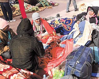 Stranded foreign workers, who fled Libya after the uprising against Libyan Leader Moammar Gadhafi, pass time playing cards by their baggage while waiting for Egyptian entry permission at the Egyptian terminal of the Egyptian Libyan border crossing of Salloum, Egypt Sunday, March 6, 2011. The U.S. and its allies should plan for a no-fly zone over Libya and consider bombing the country's airports and runways, but they should take no action unless there is an international agreement, the chairman of the Senate Foreign Relations Committee said Sunday. (AP Photo/Nasser Nasser)