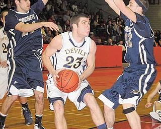 Lowellville’s Anthony Alfano (24) and Dean Donatelli (42) defend against McDonald’s Nick Rota (23) during Monday’s game in Struthers.