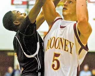 Cardinal Mooney's Kevin McGuire (5) attempts a shot against the defense of Struthers' Ja'Meire Brown (5) during Northeast Division II Sectionals, Monday, March 7, 2011 at Boardman High School.