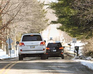 Drivers on Walker Mill Road in Boardman Township slow to a crawl as they maneuver to avoid hitting potholes.