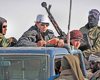 Libyan rebels who are part of the forces against Libyan leader Moammar Gadhafi ride on an armed truck near Ras Lanuf, eastern Libya, Monday, March 7, 2011.