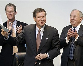 Ohio Governor John Kasich holds up paperwork signifying that American Greetings Corp., with 2,000 employees, will remain in northeast Ohio, at the company's headquarters in Brooklyn, Ohio on Monday, March 7, 2011. With Kasich are Mark Kvamme, Ohio's Development Director, left, and Morry Weiss, Chairman of American Greetings.