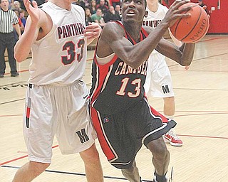 Campbell Memorial’s Dwaylon Letlo (13) drives to the basket as Mark Noble of Manchester defends during Tuesday’s Division III district semifinal at Salem High School. Campbell won 49-45.