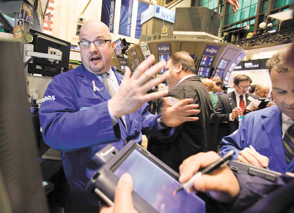 Specialist John Urbanowicz, left, works at his post on the floor of the New York Stock Exchange Wednesday, March 2, 2011. 