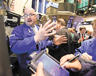 Specialist John Urbanowicz, left, works at his post on the floor of the New York Stock Exchange Wednesday, March 2, 2011.
